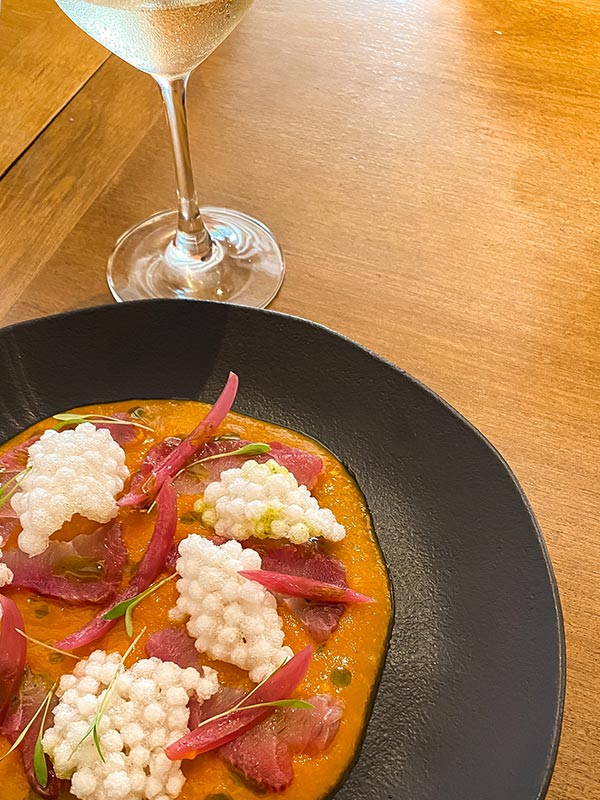 Gravlax de Peixe Branco, Emulsão de Moqueca, Crocante de Tapioca e Azeite de Coentro da chef Karine Poggio.